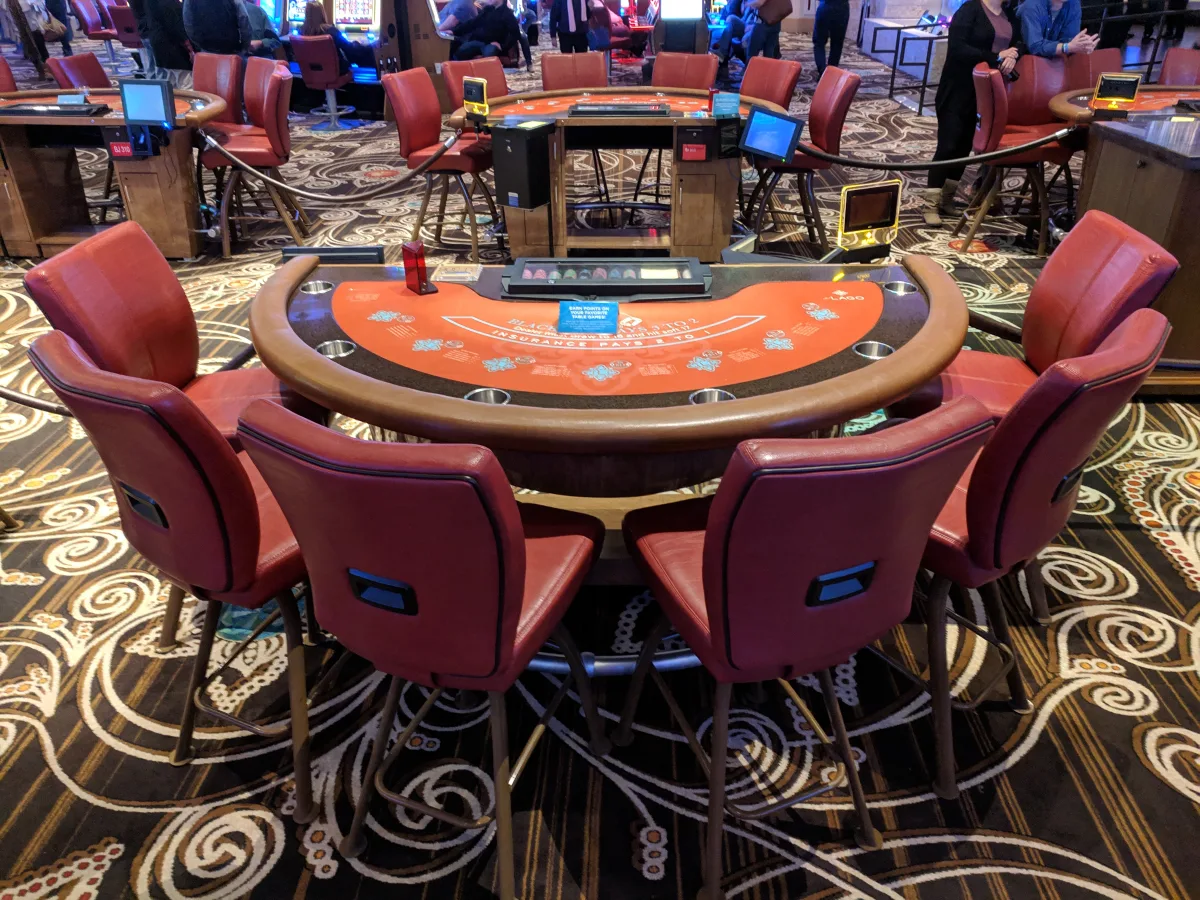 Live Dealer Games vs Digital Interfaces: What Is the Difference? 9 Dealer and players at a live blackjack table